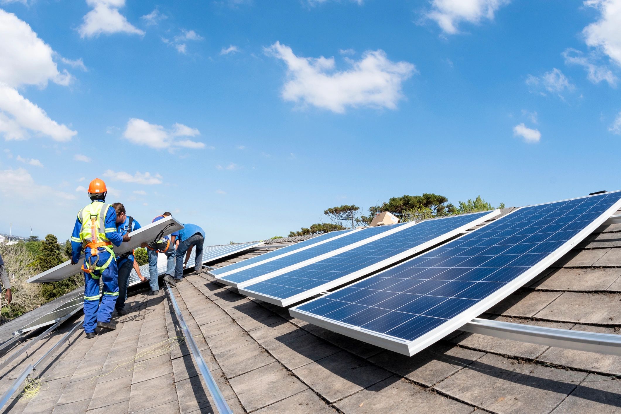 Team installing solar panels on a rooftop